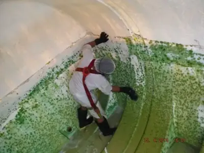 Inside view of neglected water tank showing algae growth on walls without lid